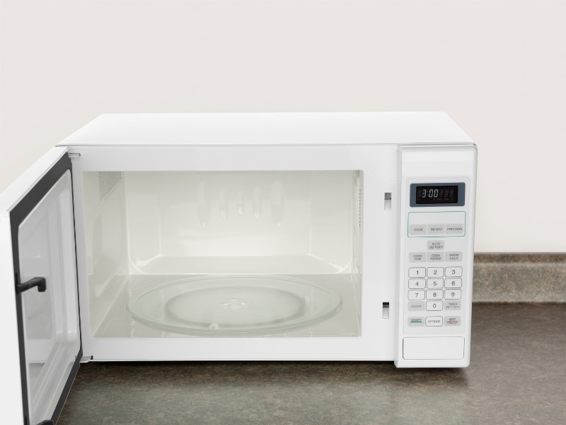 Open countertop appliance showing empty glass tray demonstrating inverter microwave vs convection design differences.
