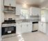 Modern white kitchen appliances including stainless steel oven, gas cooktop, rangehood and dishwasher.